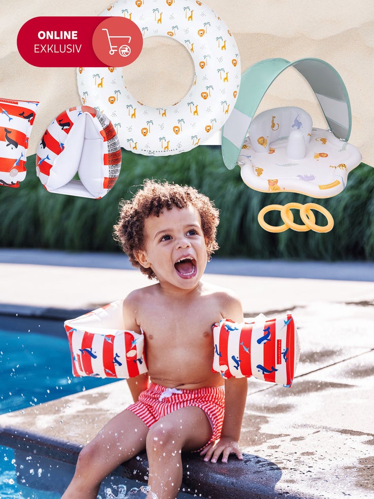 Ein Kind sitzt am Pool mit Schwimmflügeln.