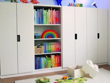 Aufgeräumtes Kinderzimmer mit Schrankwand und integriertem Bücherregal