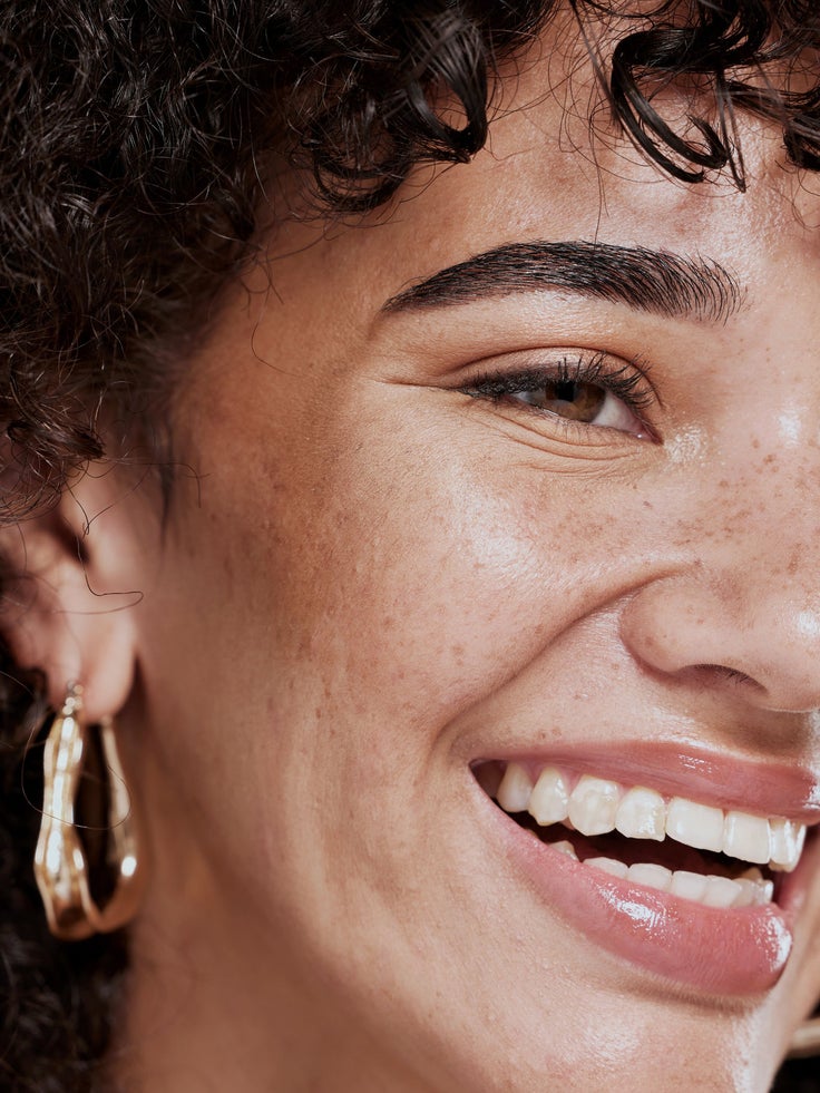 Face, beauty and smile with a model black woman in studio for skincare, cosmetics or natural treatment. Wellness, makeup and luxury with an attractive young female closeup for facial dermatology
