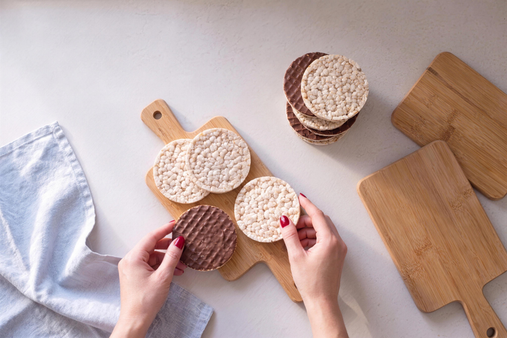 Reiswaffeln und Schokoladen-Reiswaffeln werden für Reiswaffel Variationen auf Holzbrettchen bereitgelegt.