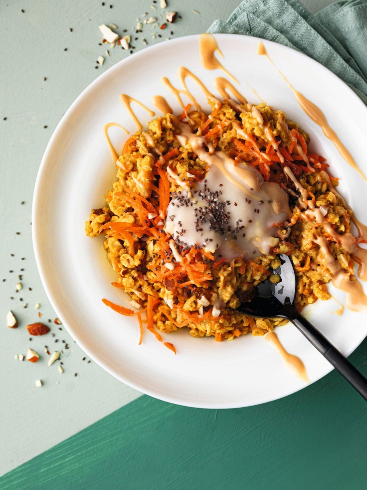 Ein weißer Teller mit Carrot Cake Porridge auf einem grünen Tisch