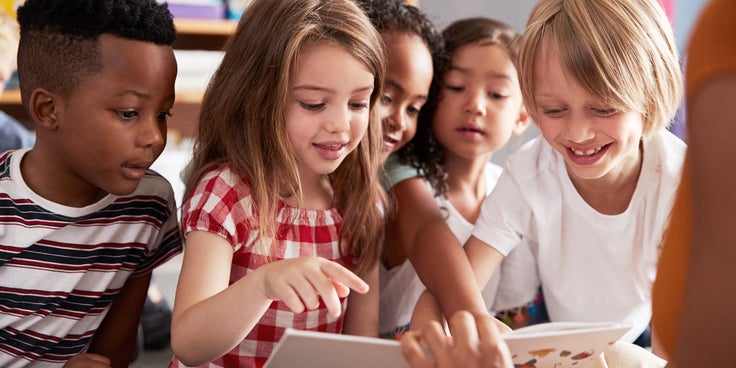Bild mit verschiedenen Kindern, die in ein Buch schauen