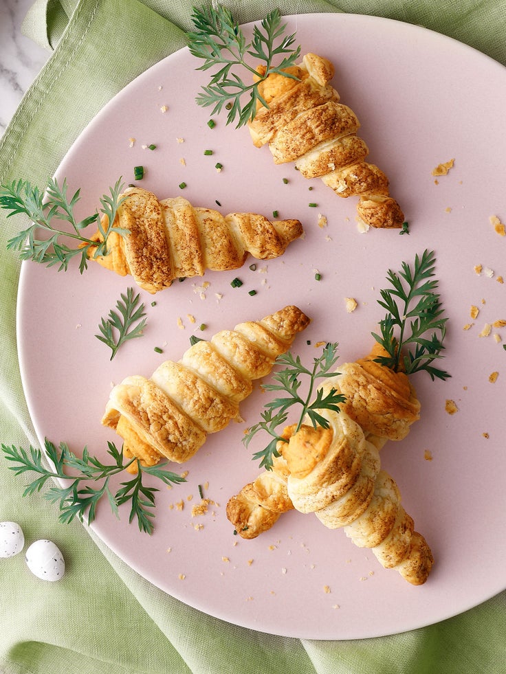 Ei rosa Teller mit 5 falschen Möhren auf einer hellgrünen Tischdecke