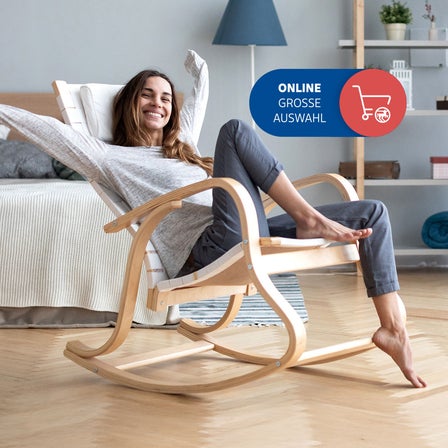 Eine Frau sitzt in einem Schaukelstuhl in einem modernen Wohnzimmer.