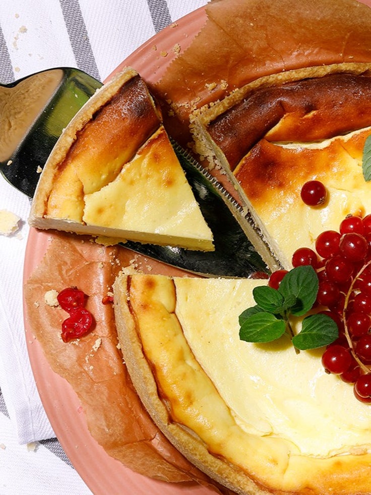 Ein angeschnittener Käsekuchen mit Früchten.