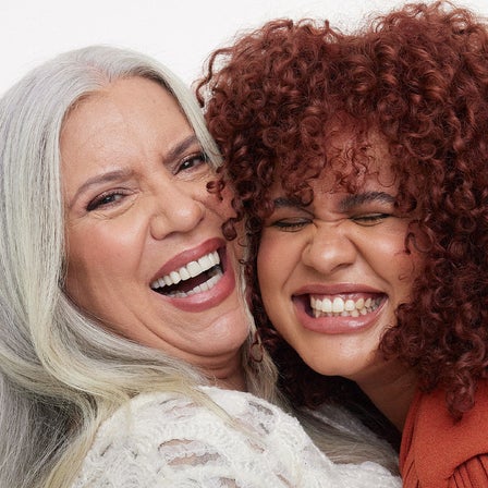 Abgebildet sind zwei Frauen, die sich umarmen