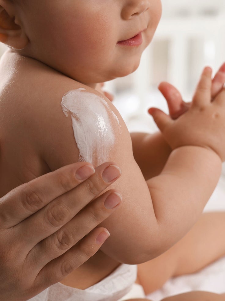 Ein Baby wird eingecremt