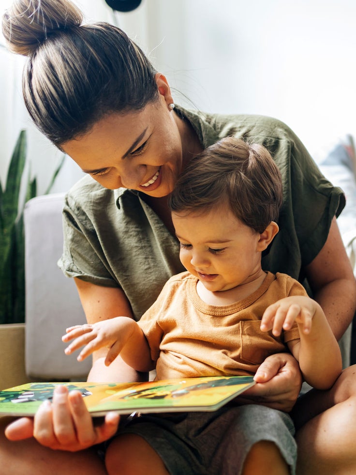 Eine Mutter schaut sich mit ihrem Kind ein Buch an.