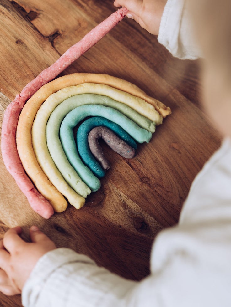Ein Kind bastelt einen Regenbogen.
