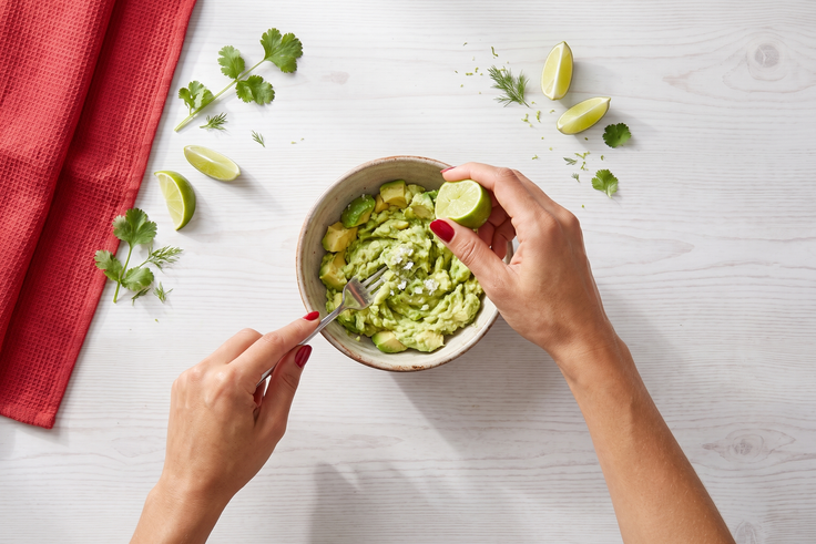 Schritt 2: Avocado wird in einer Schale mit einer Gabel zerdrückt und mit Limettensaft verfeinert.