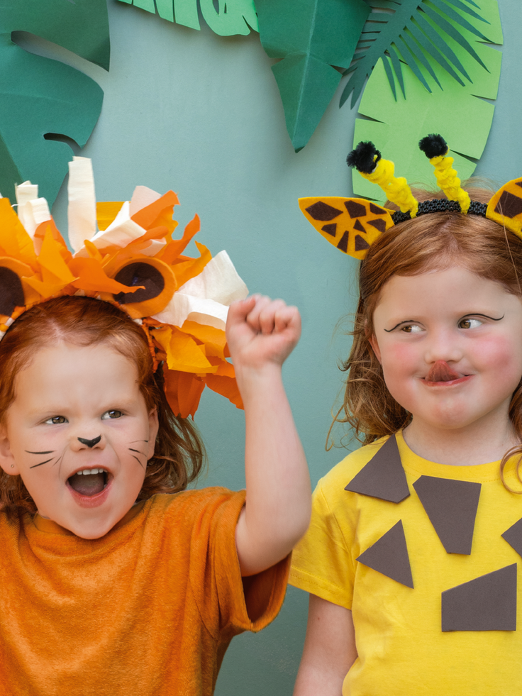 Zwei Kinder verkleidet als Löwe und Giraffe.
