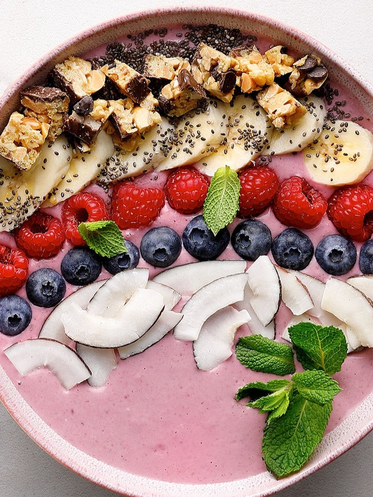Eine Frühstücks-Smoothie Bowl mit Früchten und Kokos.