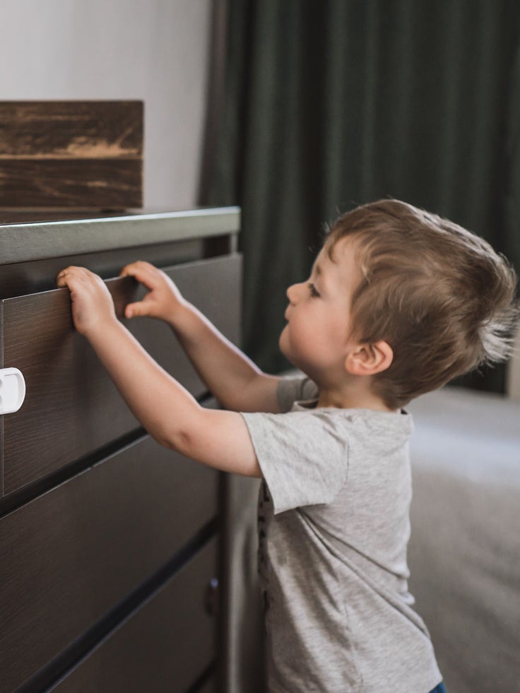 Ein Kleinkind steht vor einem Regal.