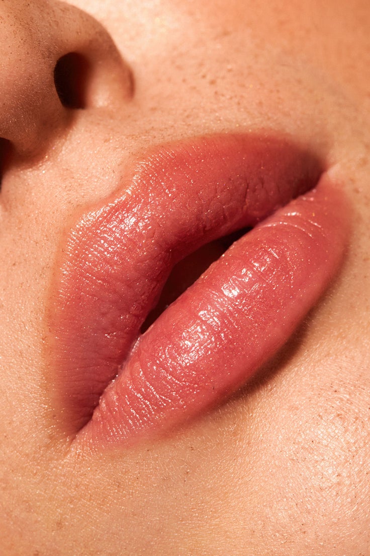 Nahaufnahme leicht geöffneter Lippen mit rosigem Treat & Tint Finish, das gepflegte, glänzende und natürlich getönte Lippen zeigt.