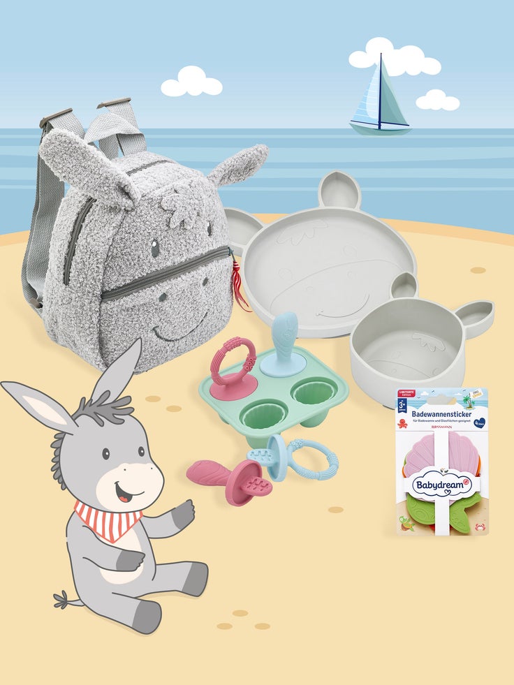 Babydream Babyartikel für Strand und Urlaub mit grauem Plüschrucksack, Kindergeschirr, Beißringen und Badewannenstickern vor maritimem Hintergrund