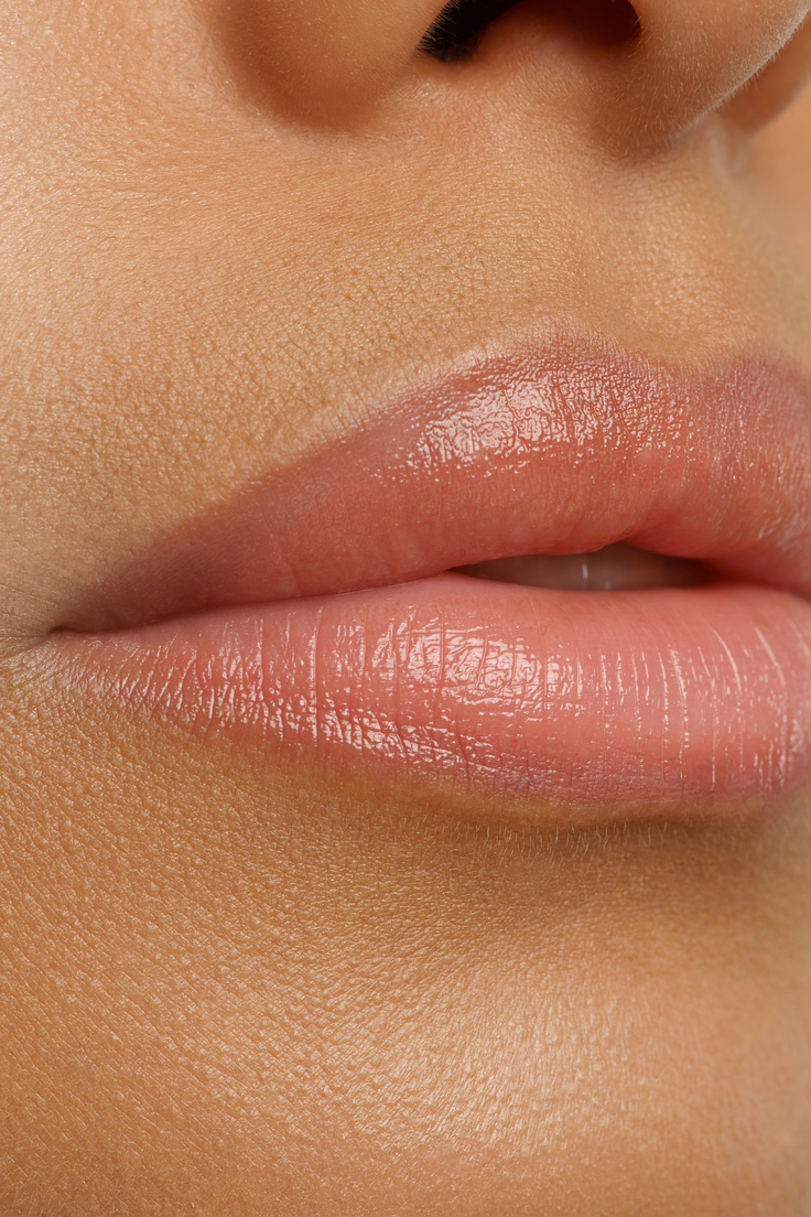 Nahaufnahme gepflegter Lippen mit zartem Gloss-Finish und natürlicher rosiger Farbe.