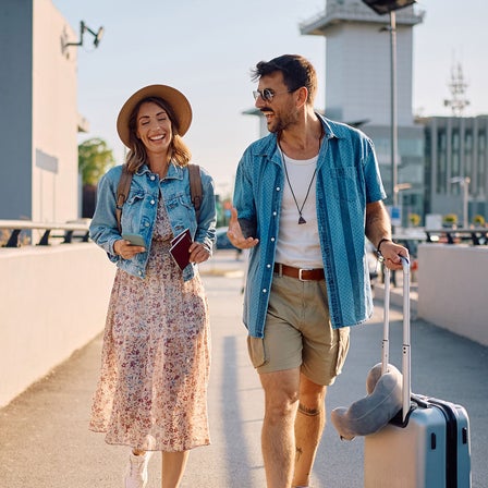 Eine Frau und ein Mann mit Rucksack und Koffer unterwegs.
