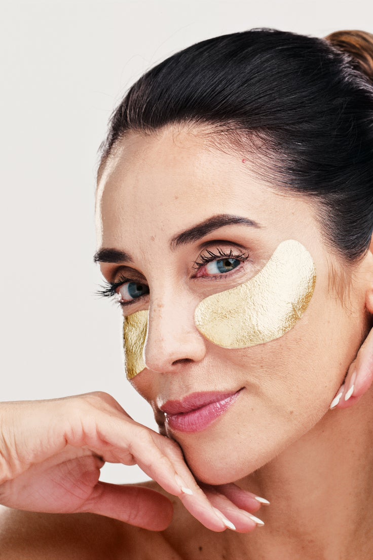 Frau mit Augenpads unter den Augen zur kühlenden und abschwellenden Vorbereitung der Partie vor dem Auftragen von Make-up.