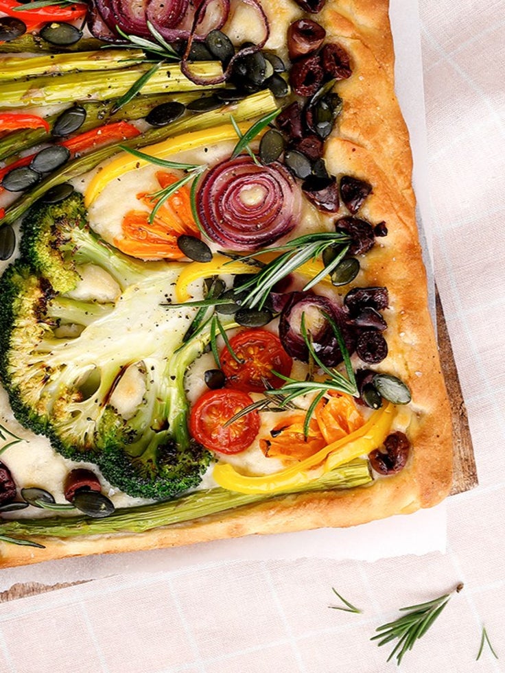 Ein belegtes Foccacia mit Zwiebeln, Brokkoli, Tomaten und anderen Gemüsesorten