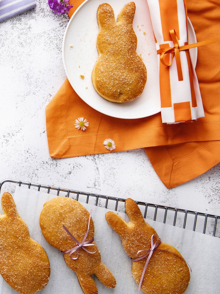 Ein Teller mit einer orangfarbenen Serviette und 4 kleinen Quarkhasen