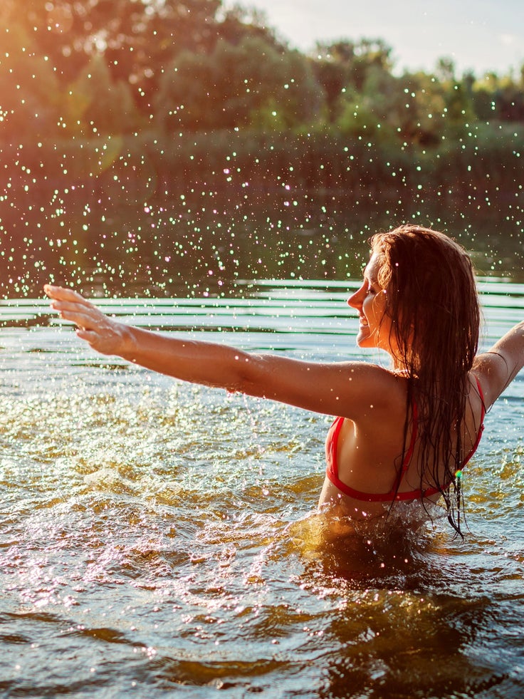Frau schwimmt im See und genießt das Wasser trotz Periode als Einstieg zum Thema Schwimmen mit Periode
